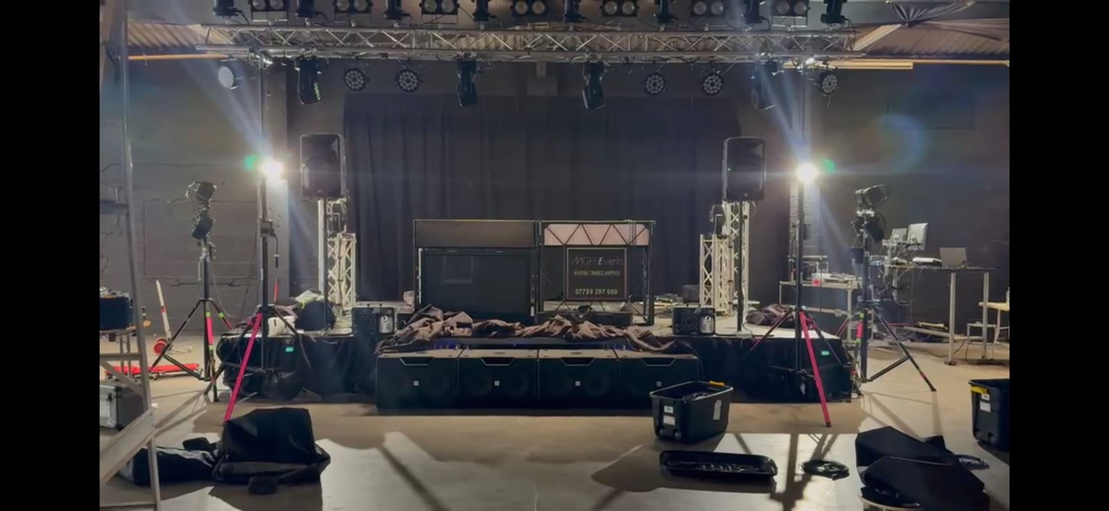 Full truss lighting rig with PA stacks and DJ booth set up on stage